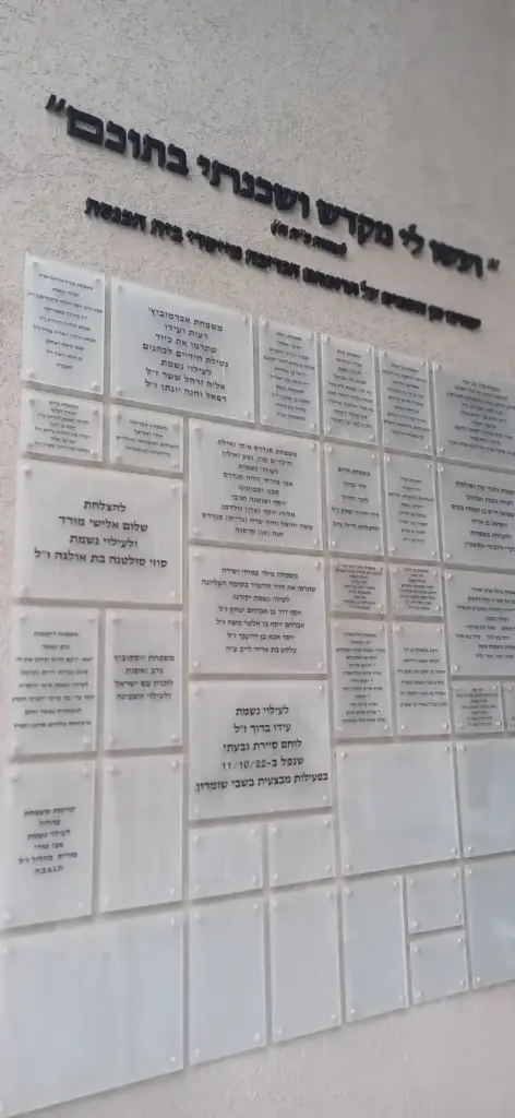שילוט מואר עם שמות וחלקי מידע על קירות, כולל שלטים מוארים לעסקים.